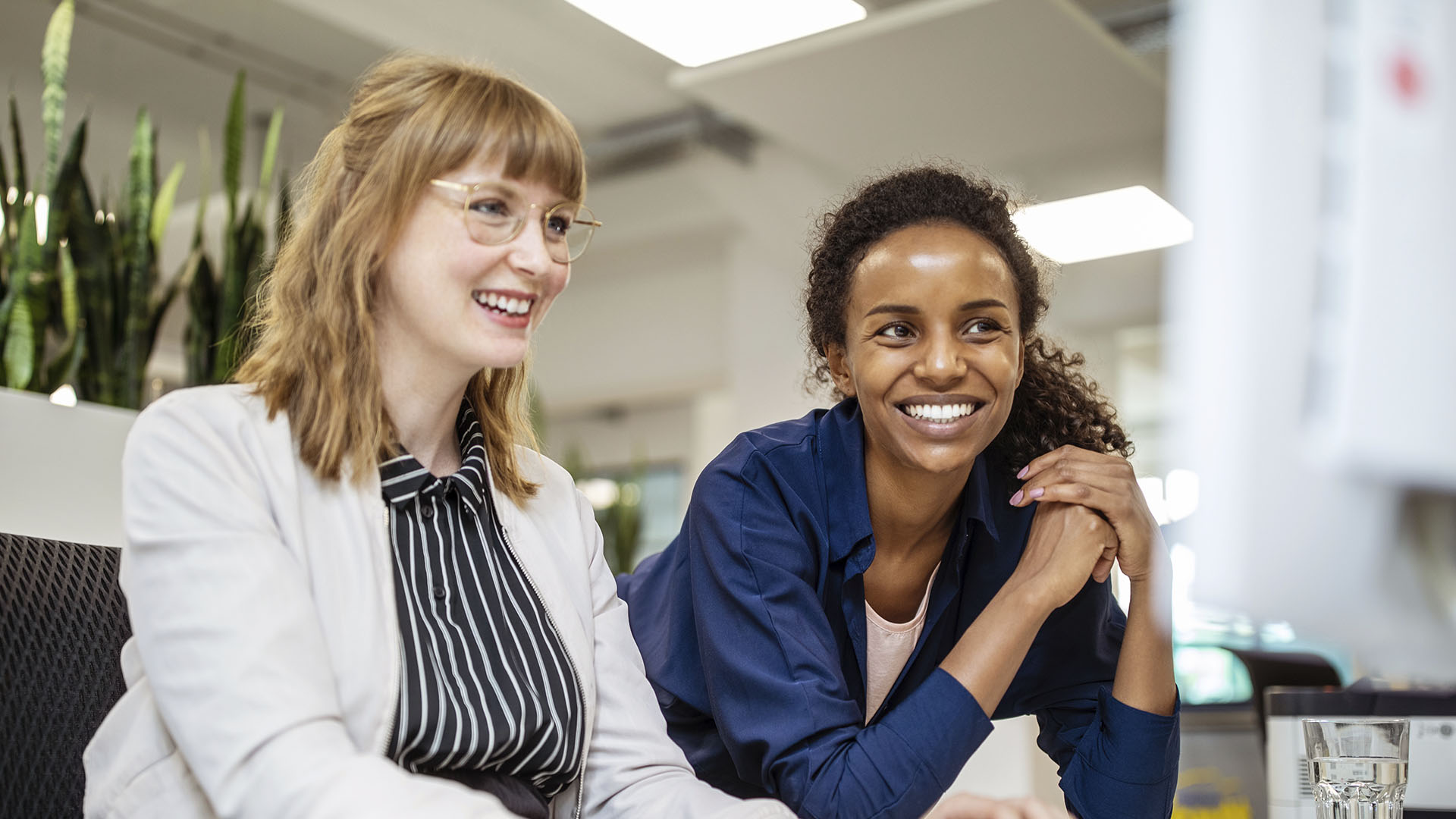 smiling office workers talking about onboarding and leave management systems