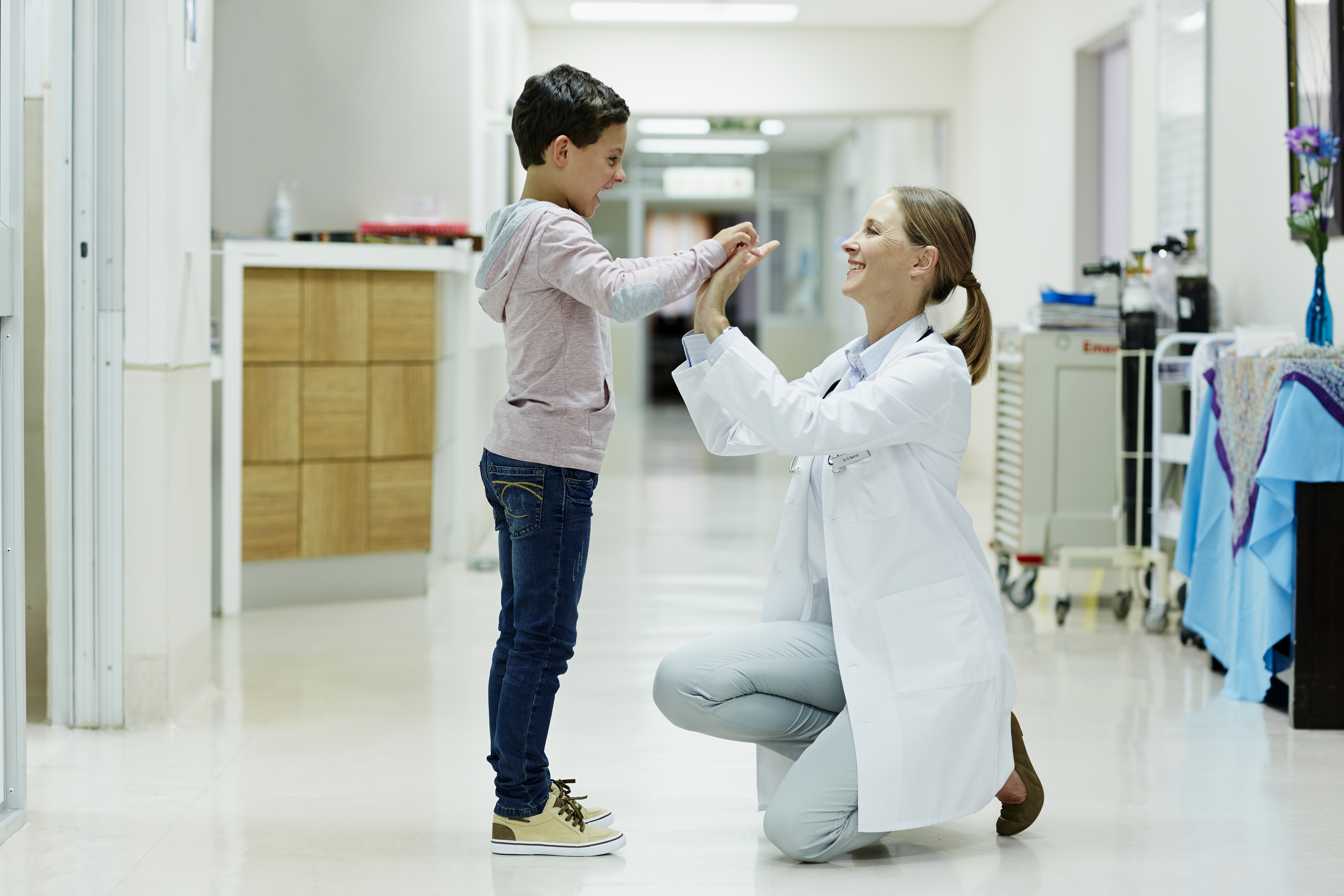 doctor and child high-fiving in hospital