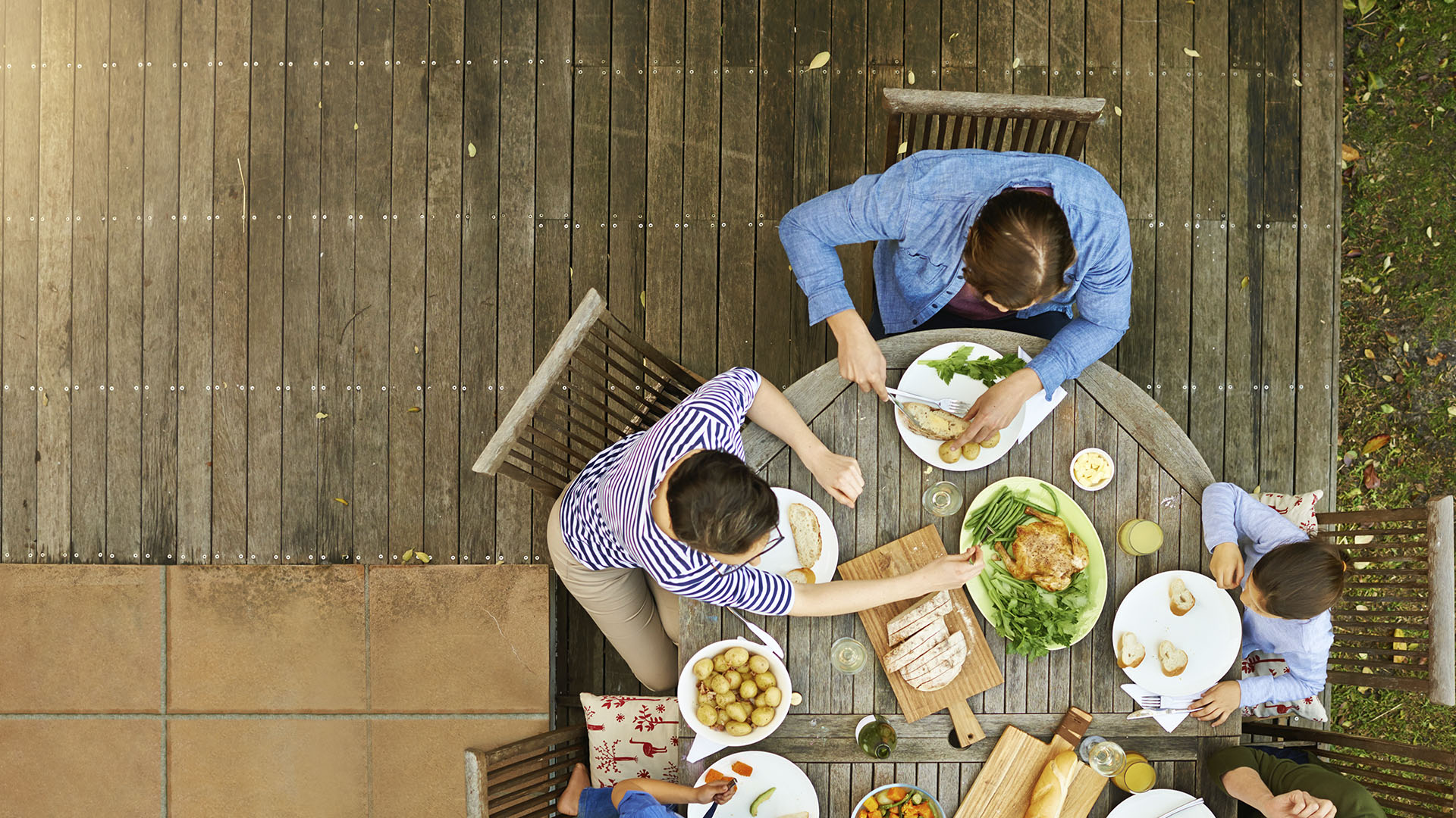 group sitting outside around a table of healthy food 