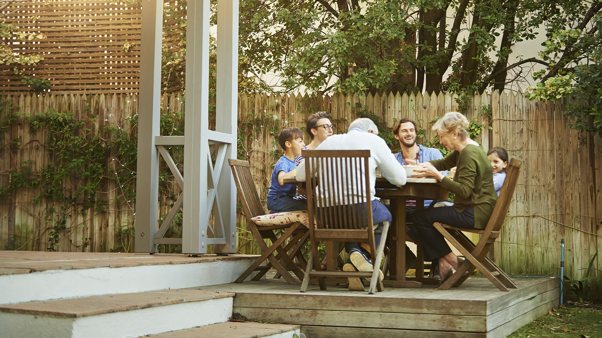 group sitting outside around a table of healthy food 