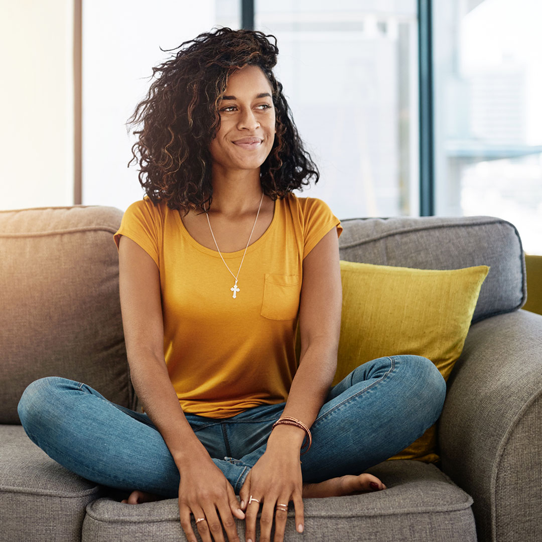 Woman sitting on the couch in her home